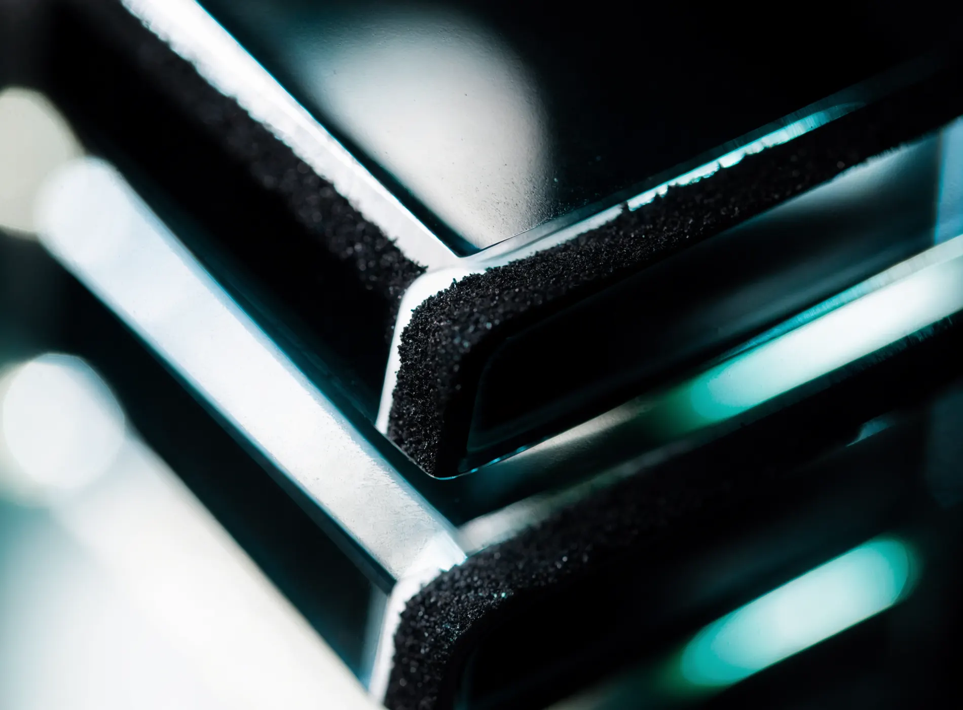 Precision glass surface with black sand and restrained cyan edge light